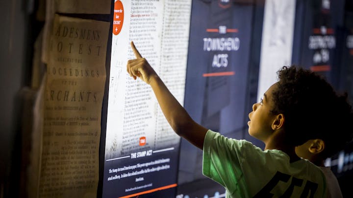 A young visitor uses the Posters of Protest touchscreen interactive in the Museum galleries over Labor Day Weekend in 2022.