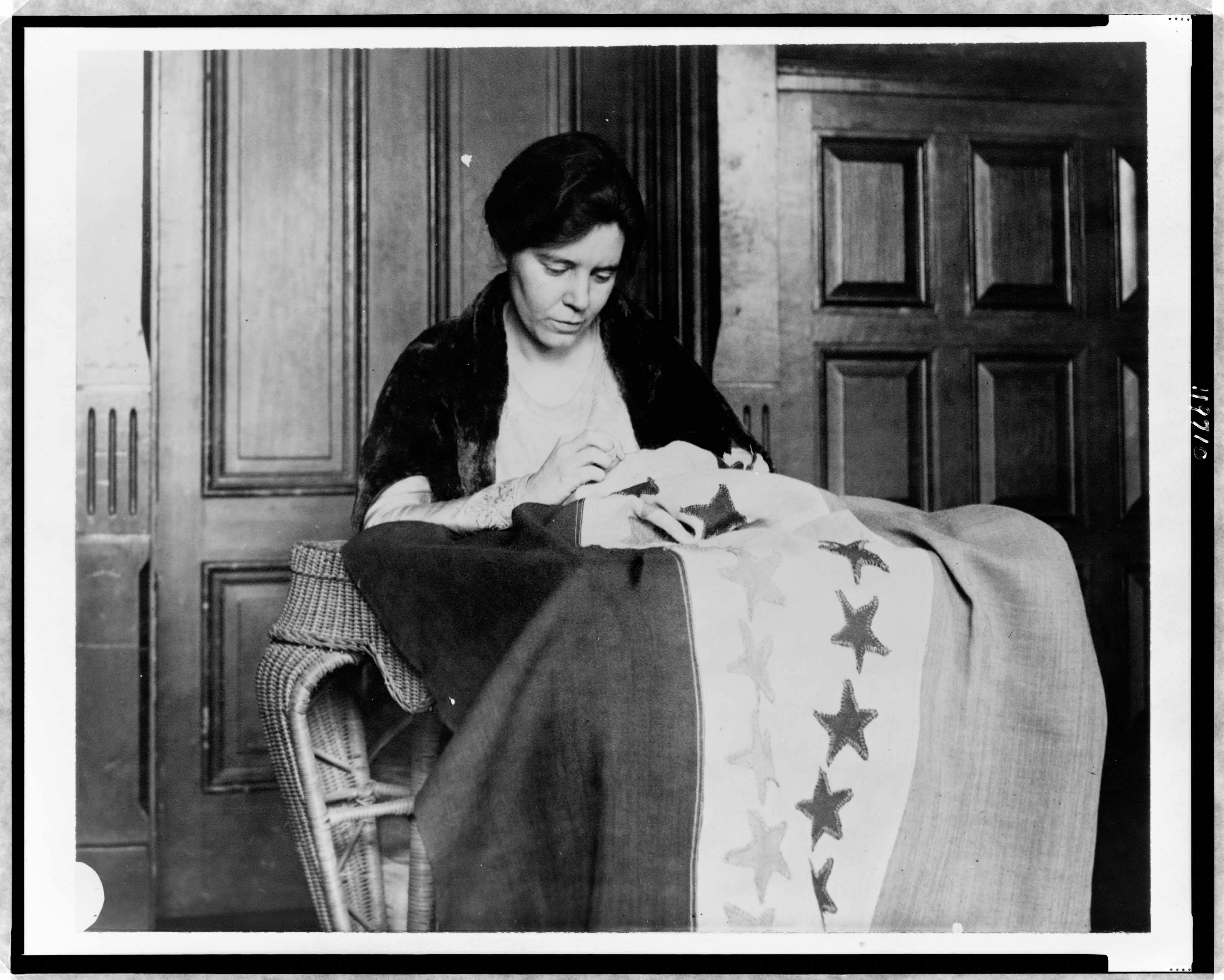 A photo of Alice Paul sewing suffrage flag.