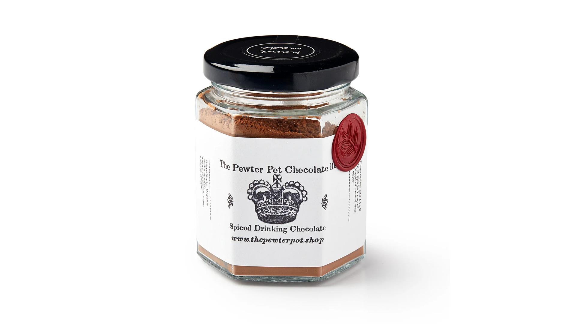 A jar with a black lid and white label with brown powder inside