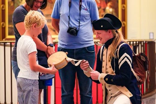 A Costumed Living History Interpreter showing a young child a canteen over Labor Day Weekend