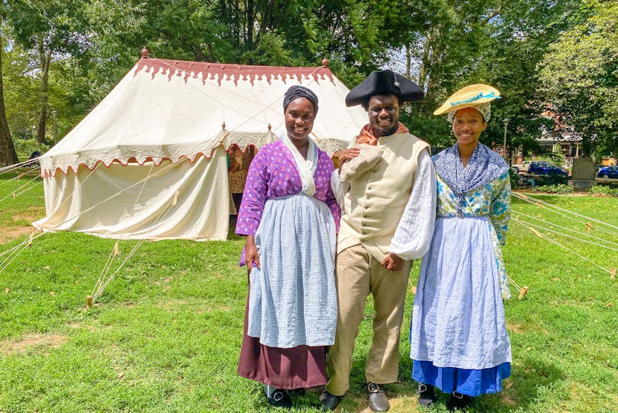 Three students from the Museum's Living History Youth Summer Institute pose for a photo in from the Museum's recreated George Washington's tent in Clark Park.