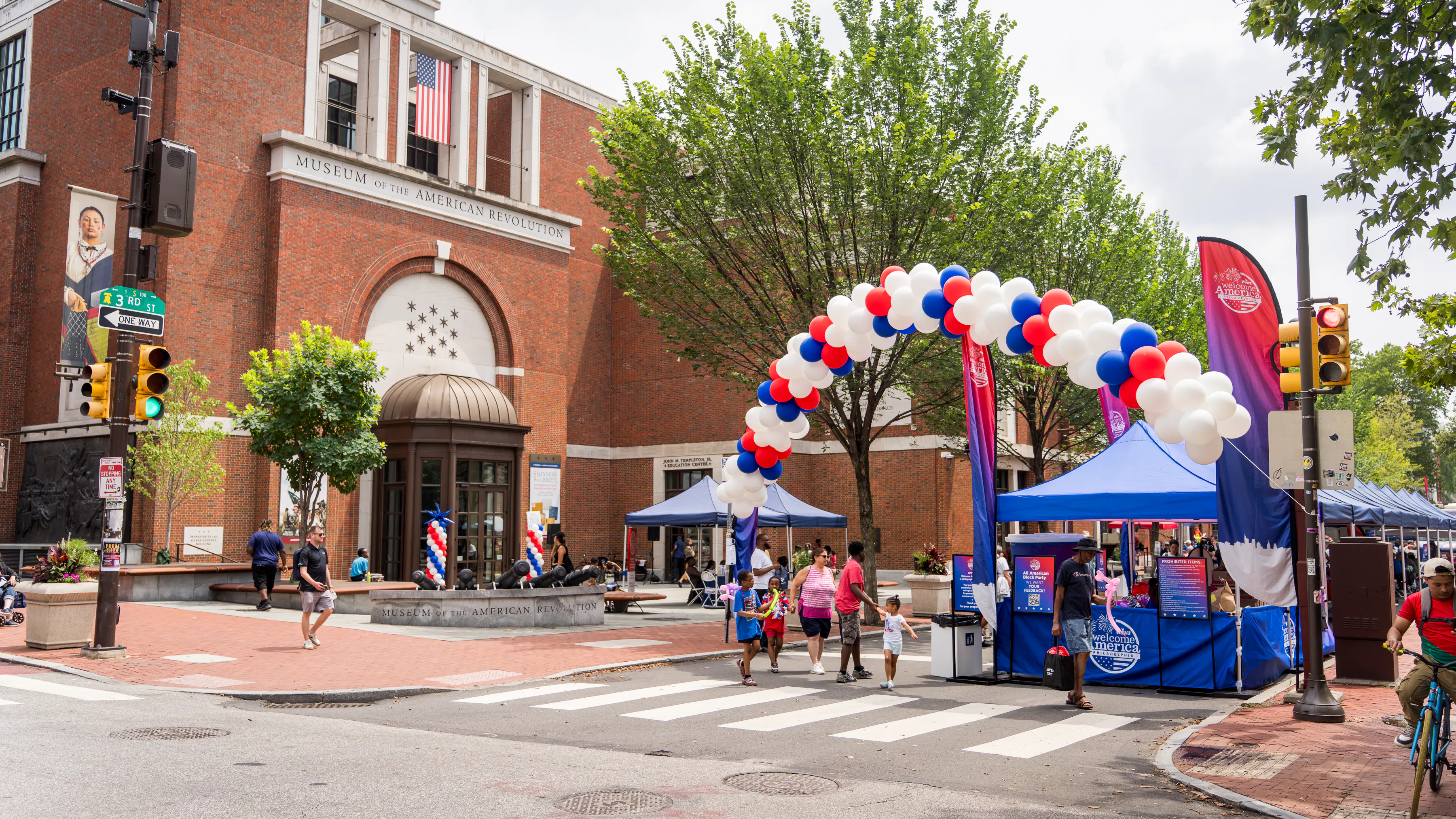 Museum exteriror with red, white, and blue balloon arch
