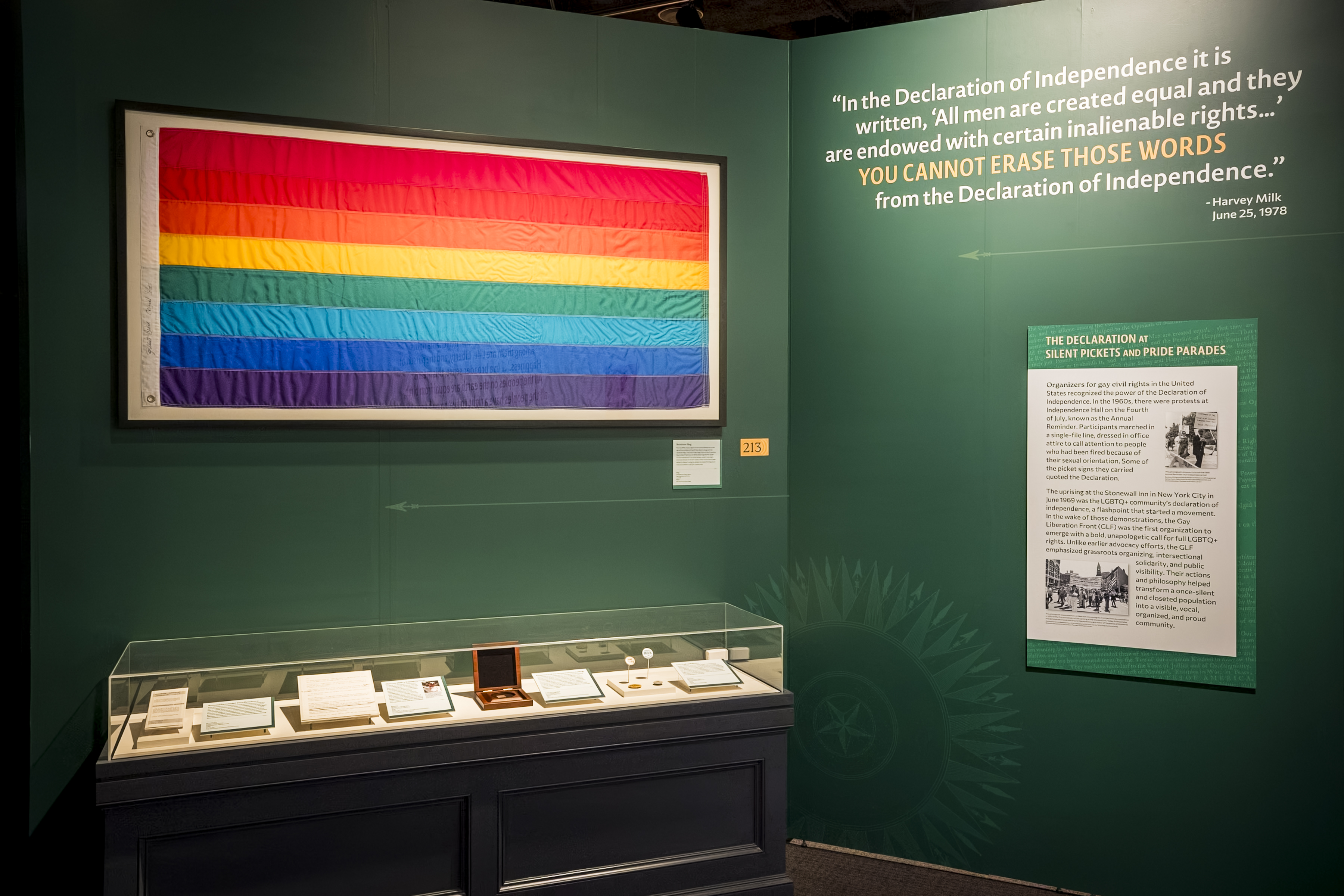 A Pride flag and artifacts displayed in The Declaration's Journey