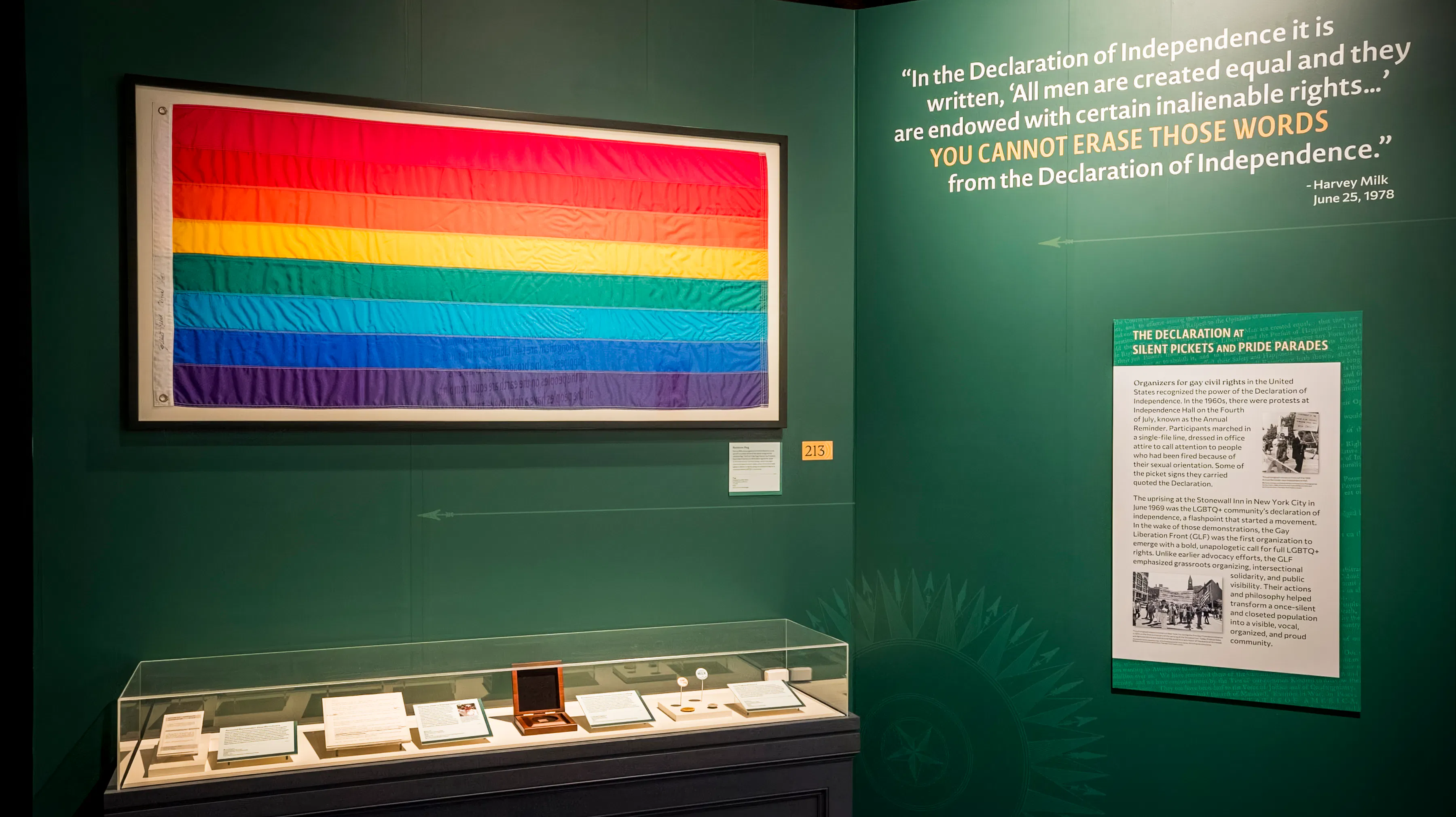 A Pride flag and artifacts displayed in The Declaration's Journey