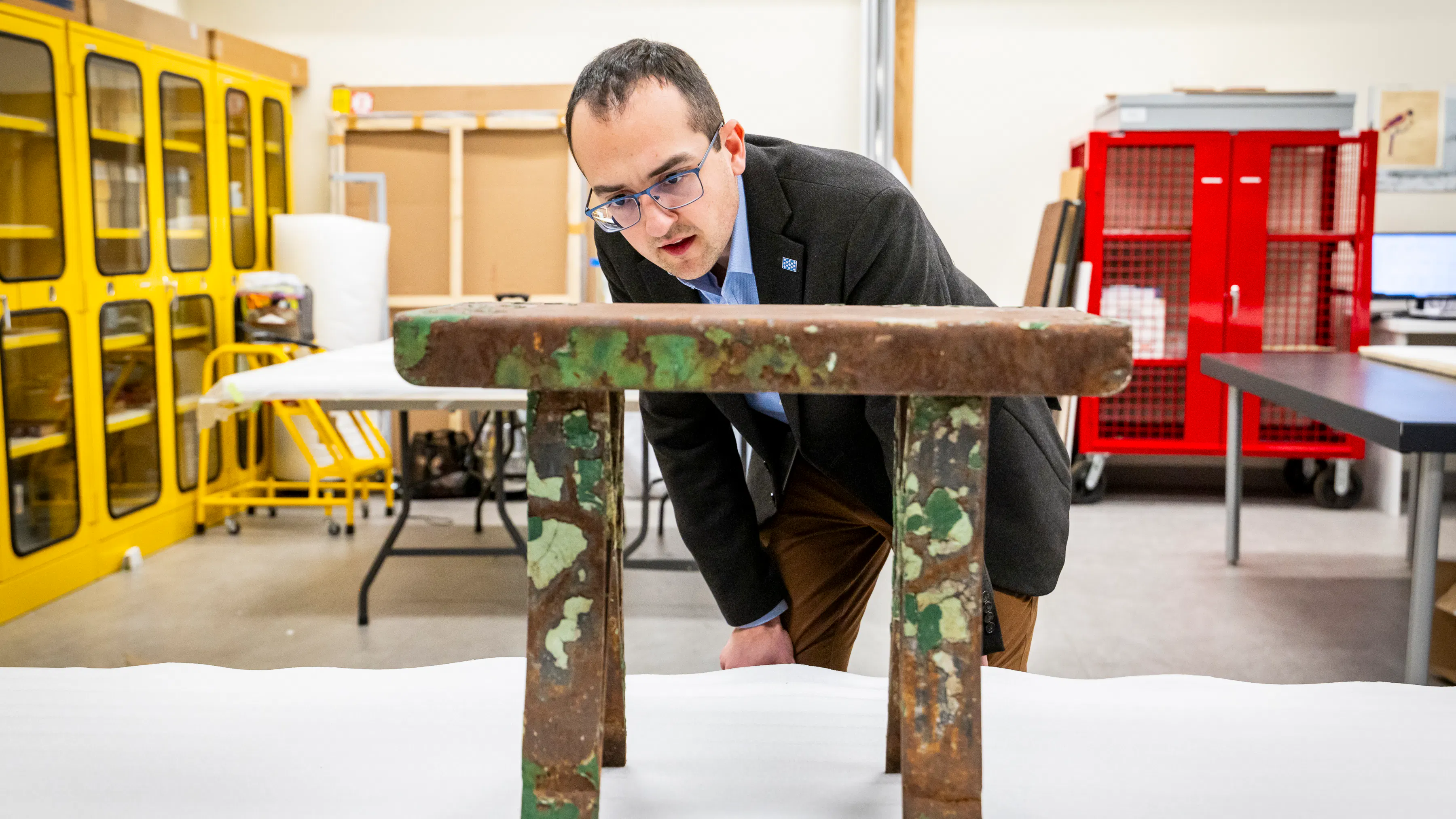 Man in suit looking at rusted bench on a table
