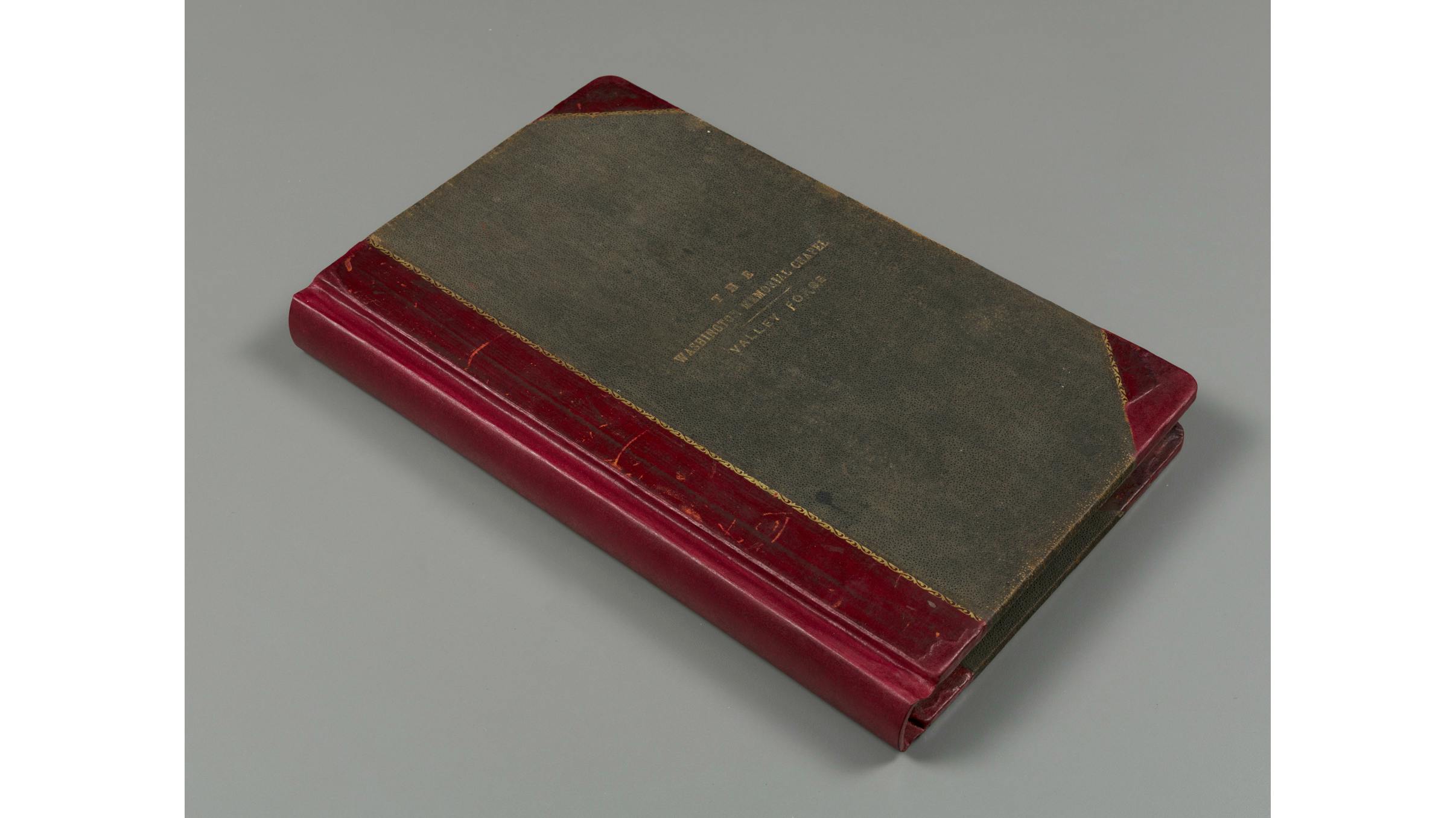 The cover of the visitor register for the Washignton Memorial Chapel at Valley Forge with a gray cover and red details
