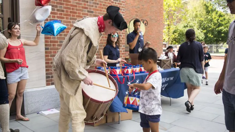 Fife drum player teaching a child