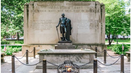 The Tomb of the Unknown Revolutionary War Soldier with a statue of George Washington in Washington Square Park in Philadelphia.