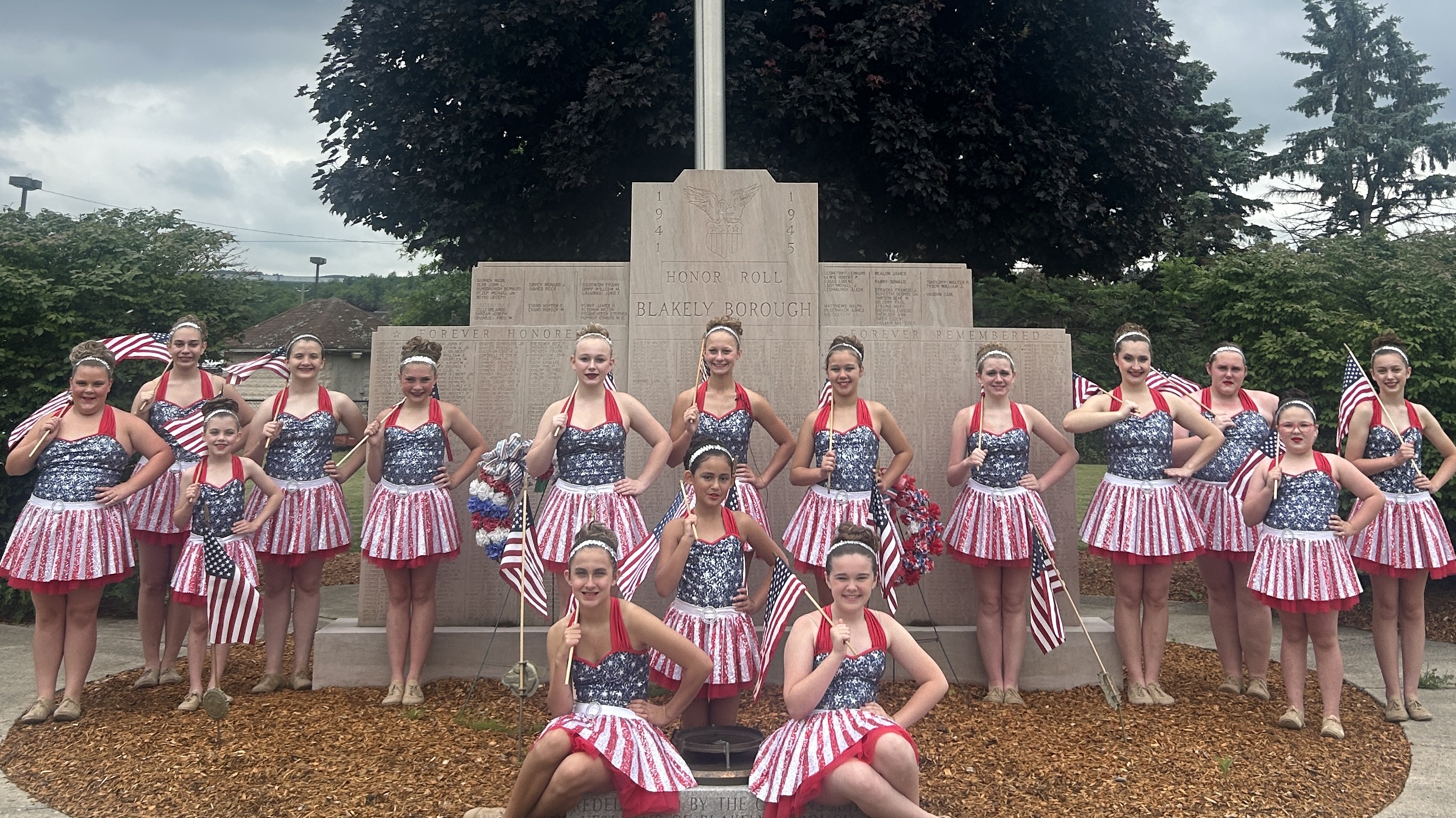 A group of young women pose in red, white, and blue costumes