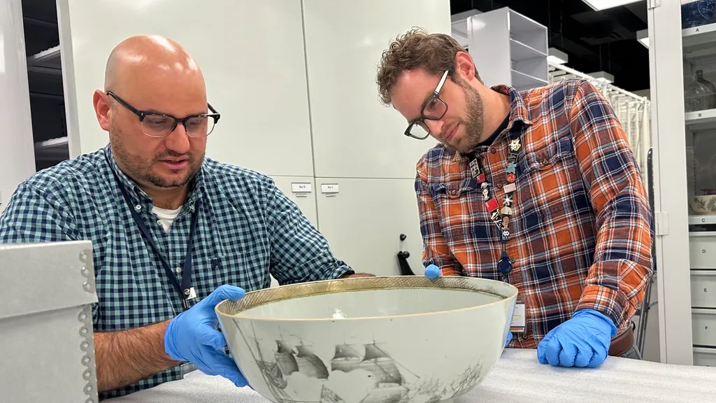 Two men look at a porcelain bowl