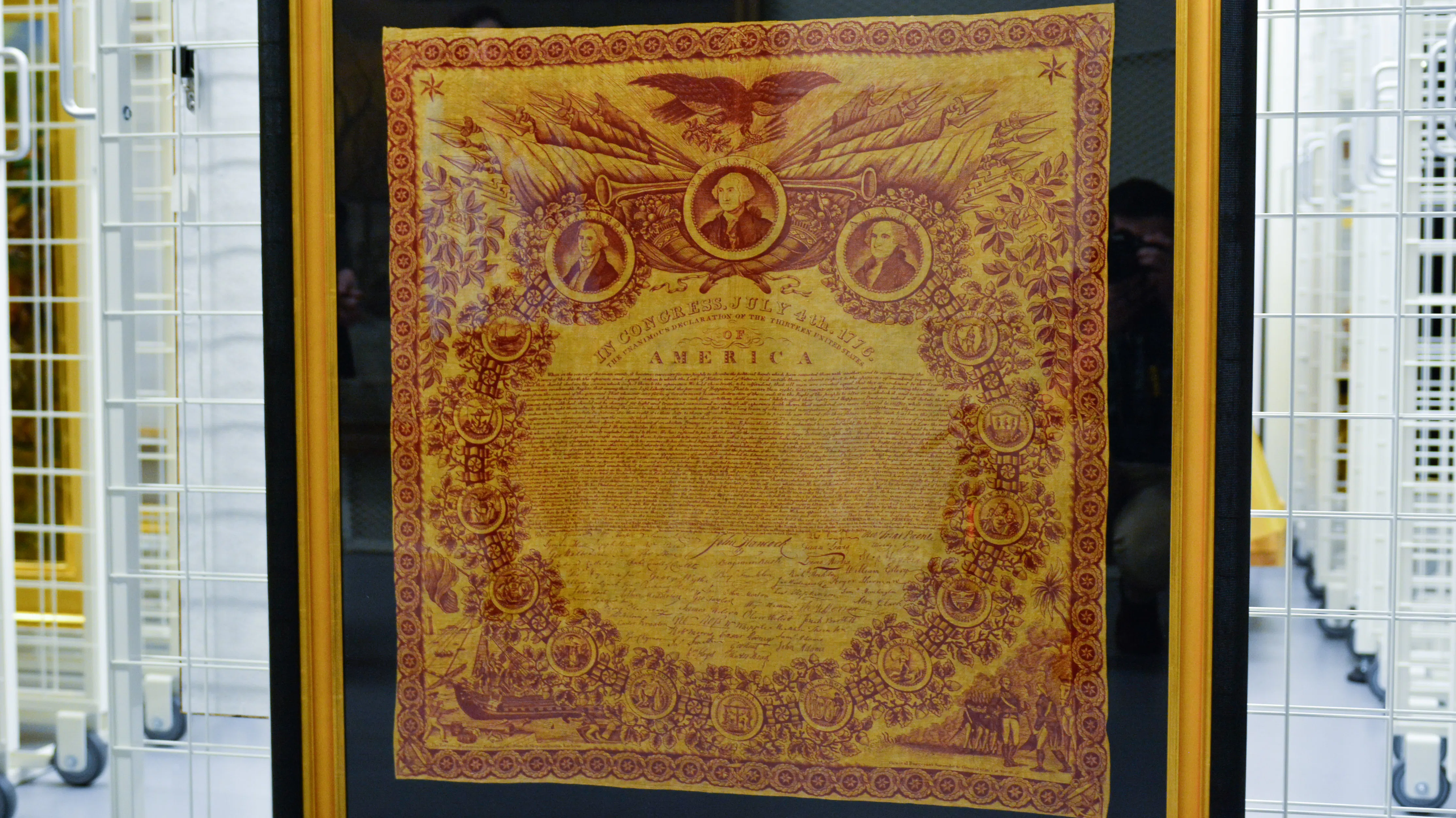 A handkerchief with red detail features the words of the Declaration of Independence.