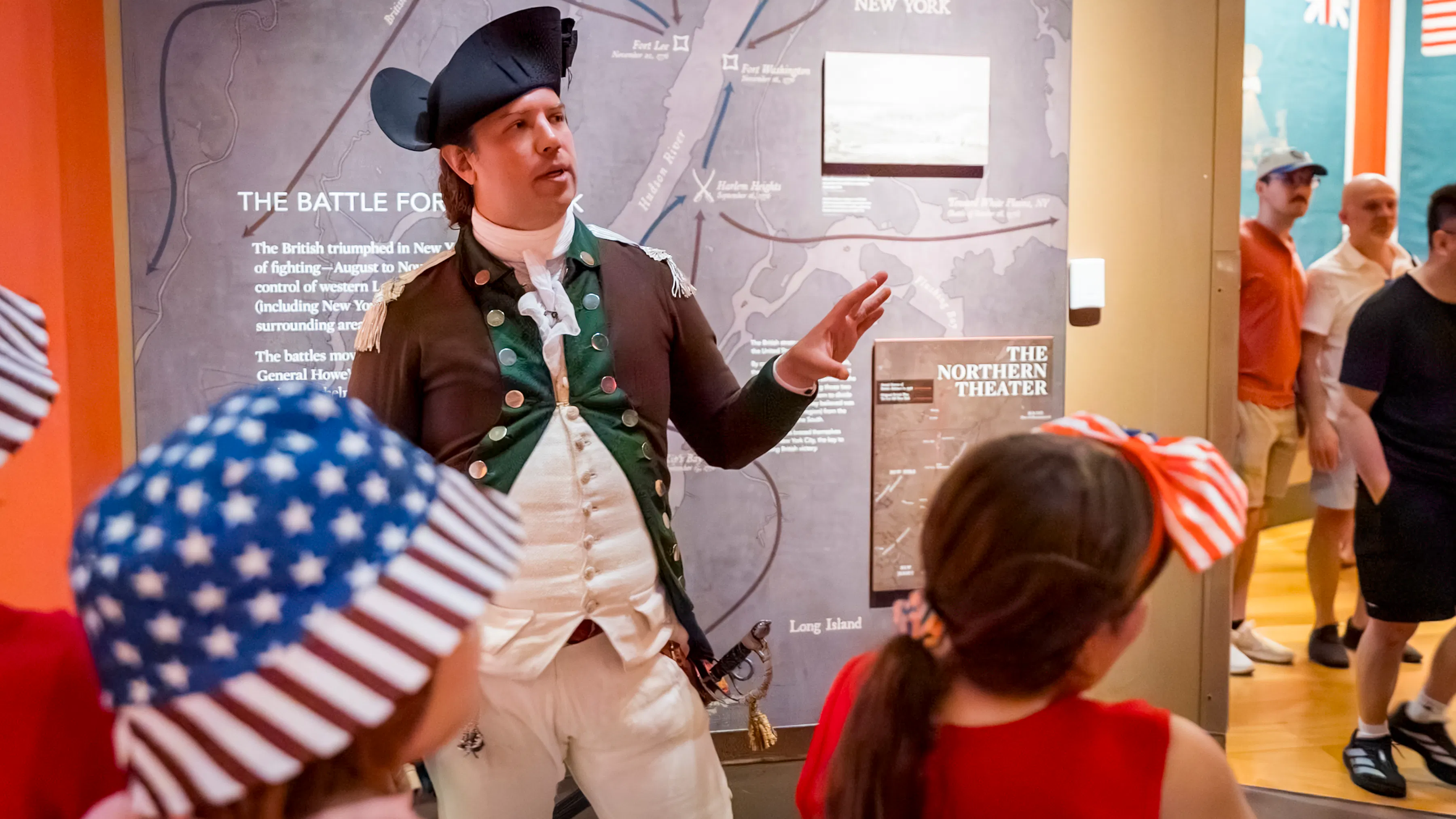 Man in Revolutionary soldier clothing talks to visitors