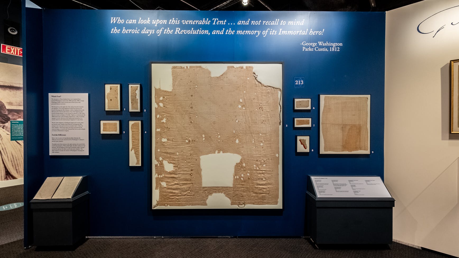 This blue wall in the Witness to Revolution exhibit features nine fragments anchored by a large piece in the middle of Washington's tent that were cut from the original.