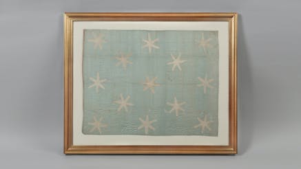 General George Washington Standard Flag featuring 13 six-pointed stars on a light sky blue silk field in the Museum's collection.