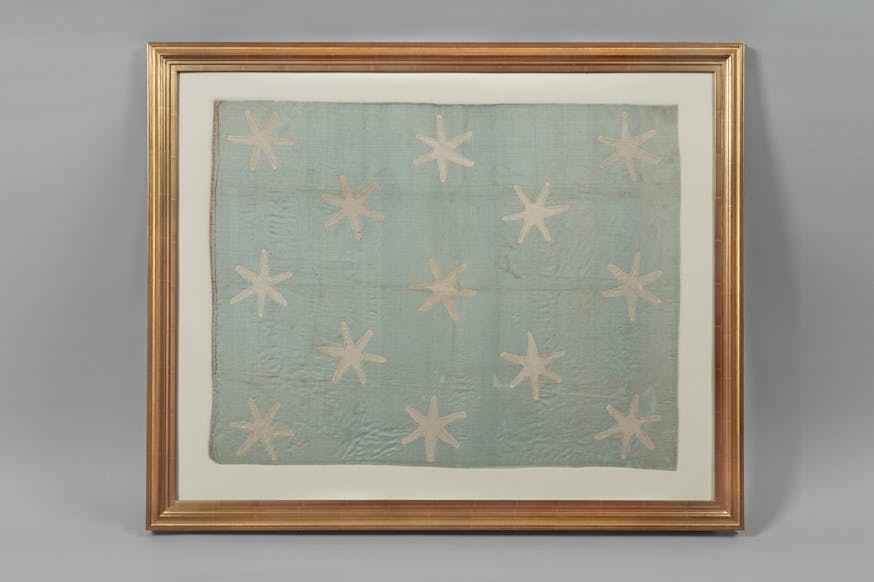 General George Washington Standard Flag featuring 13 six-pointed stars on a light sky blue silk field in the Museum's collection.