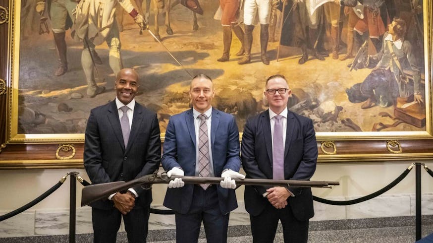From left to right, FBI Philadelphia Special Agent in Charge Wayne A. Jacobs, Special Agent Jake Archer of the FBI Art Crime Team, and Assistant Special Agent in Charge Jamie Milligan pose with a Revolutionary War-era musket that was returned to the Museum of the American Revolution in Philadelphia on July 1, 2024.