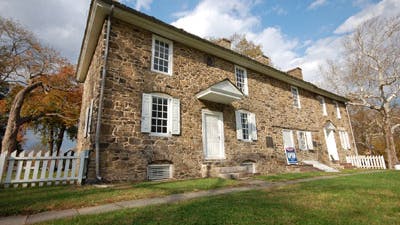 This image shows the stone house with white shutters that is the Thompson-Neely House and Farmstead.