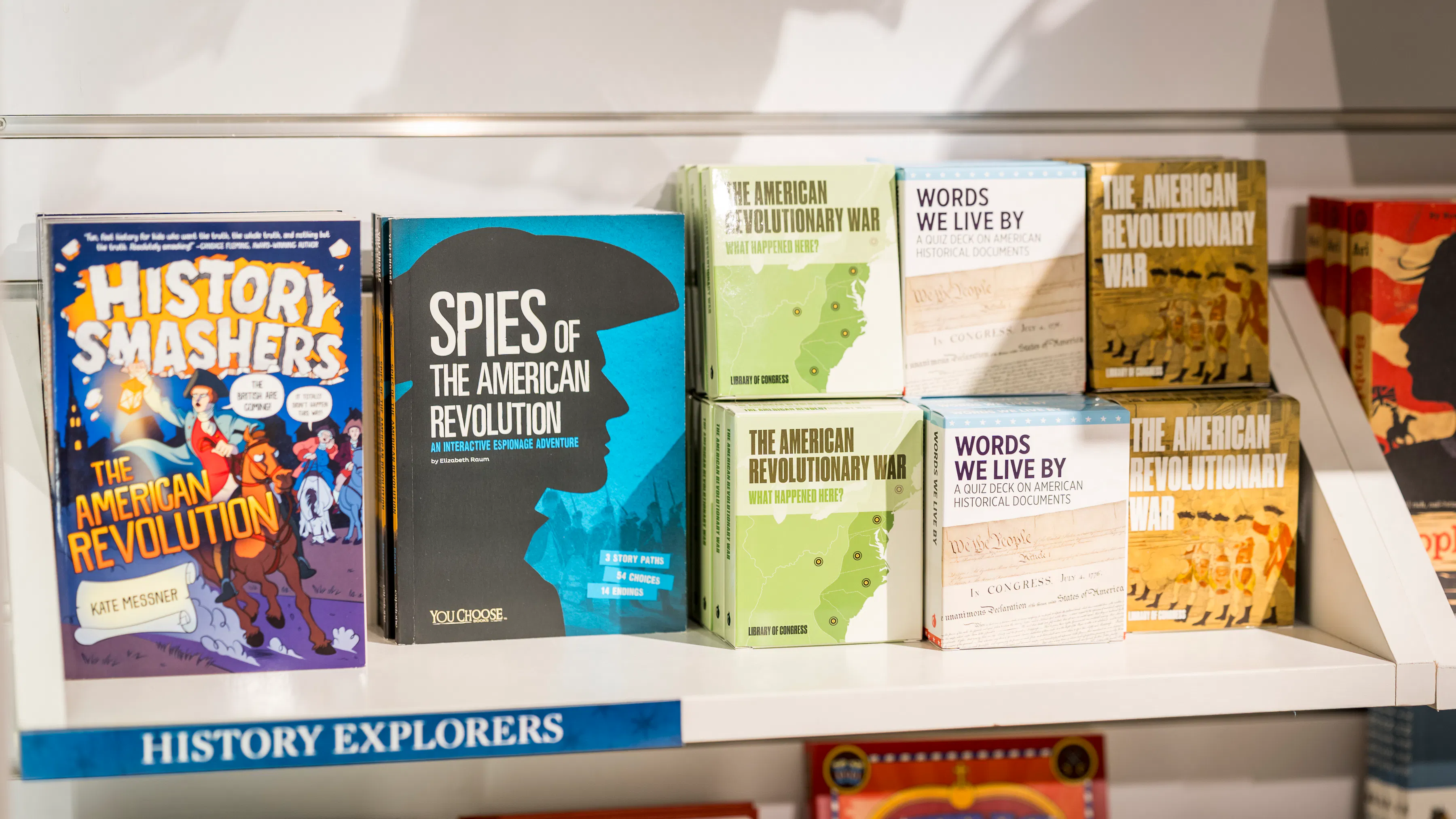 Kids' history-themed books stacked on a shelf