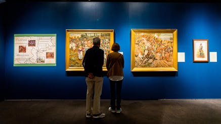 Two visitors view paintings in the Museum's Liberty exhibit.