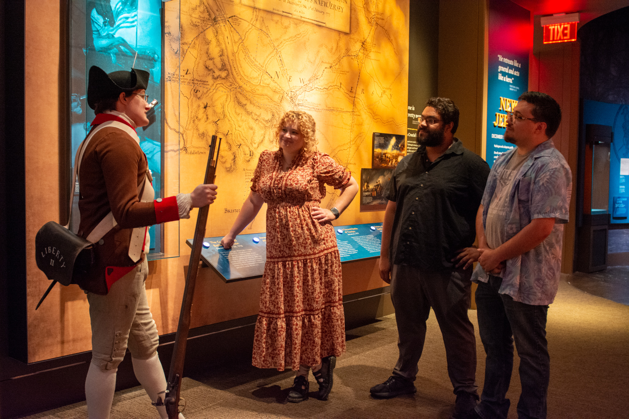Two people talk to a costumed interpreter in the Museum