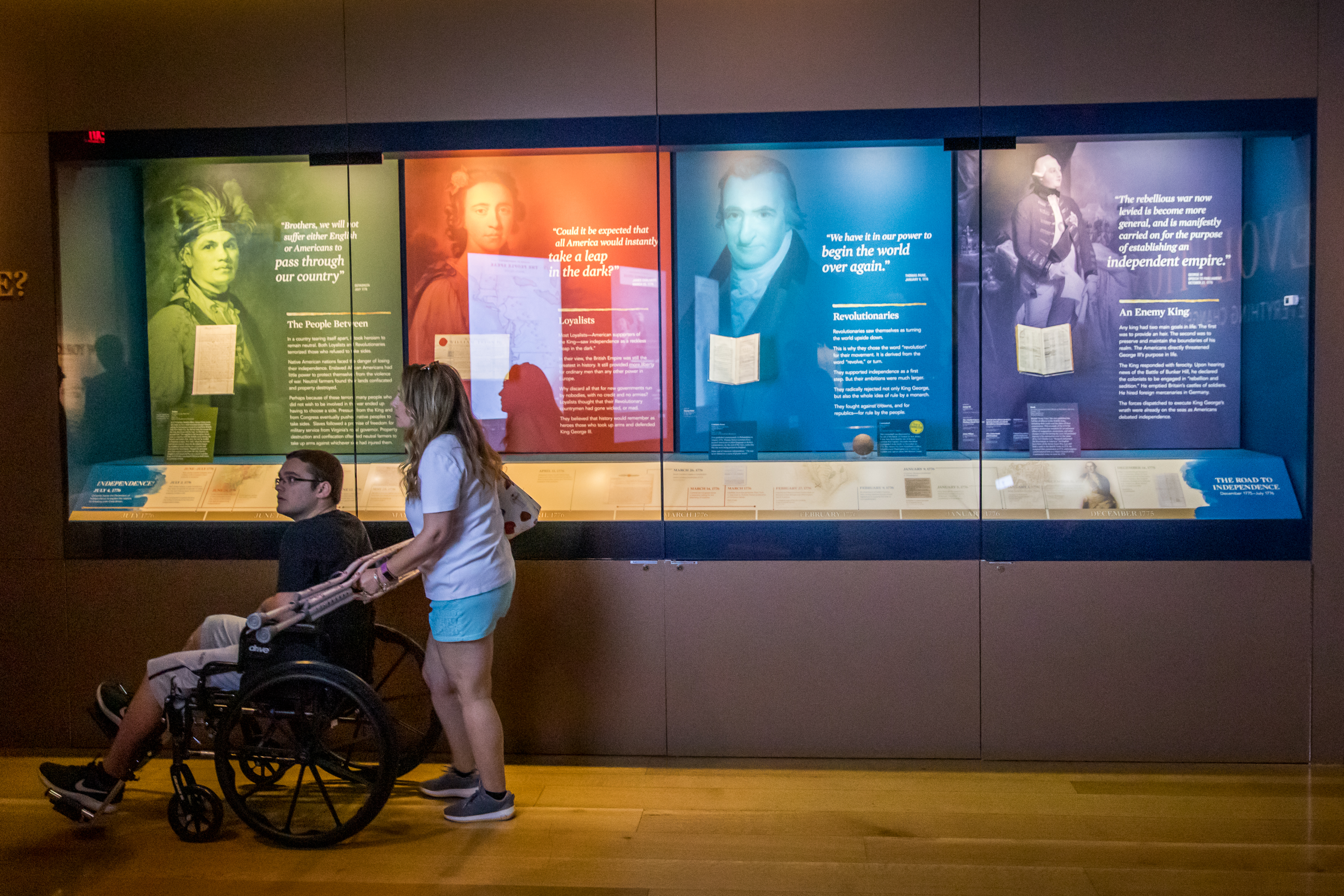 Guests in front of a case with four distinct colored sections
