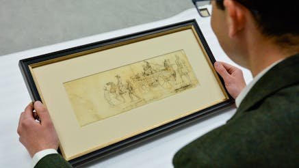 Curator Matthew Skic holds and views the framed eyewitness sketch of the North Carolina Brigade and women camp followers marching through Philadelphia.