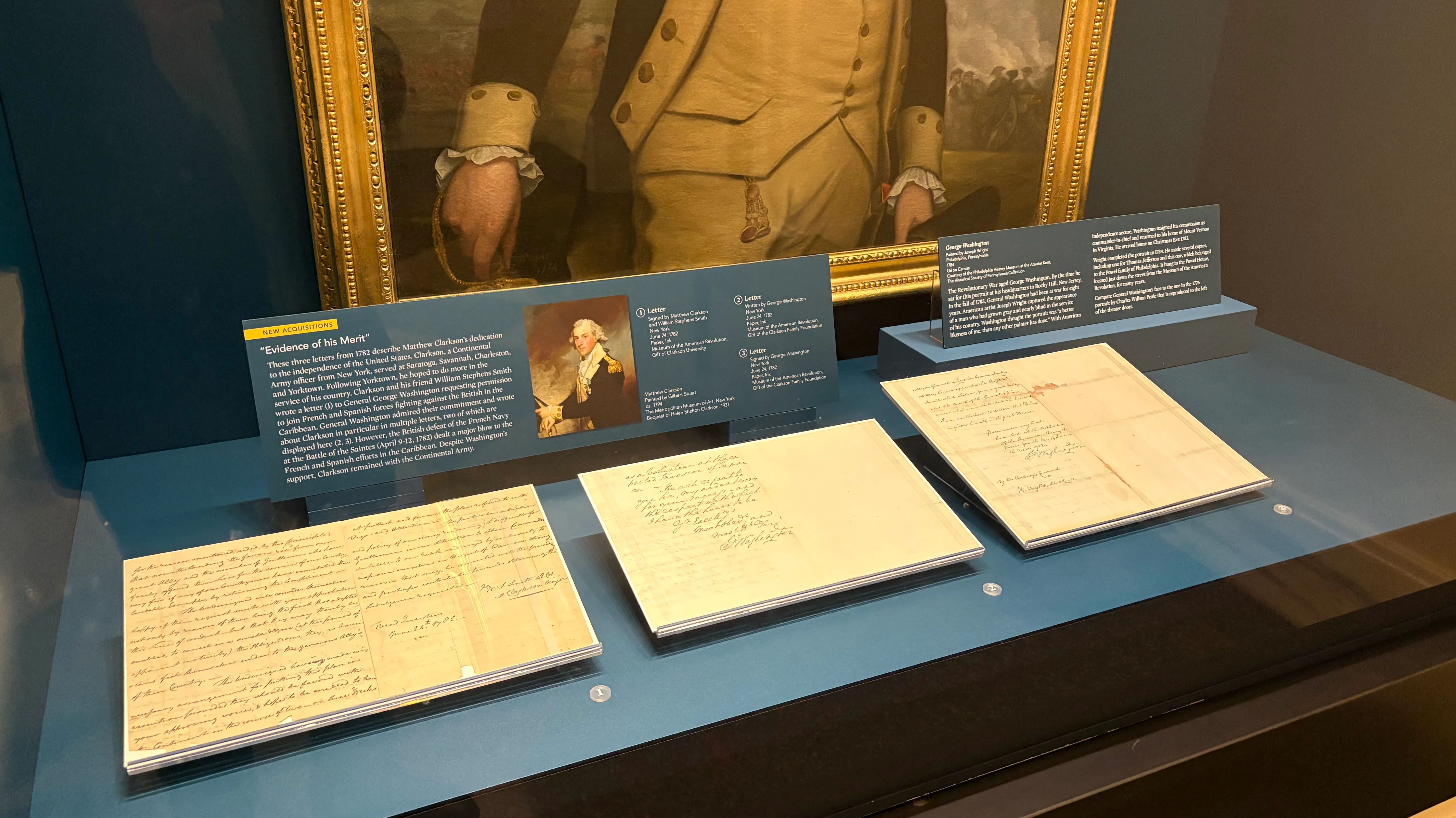 Three old documents displayed in a case