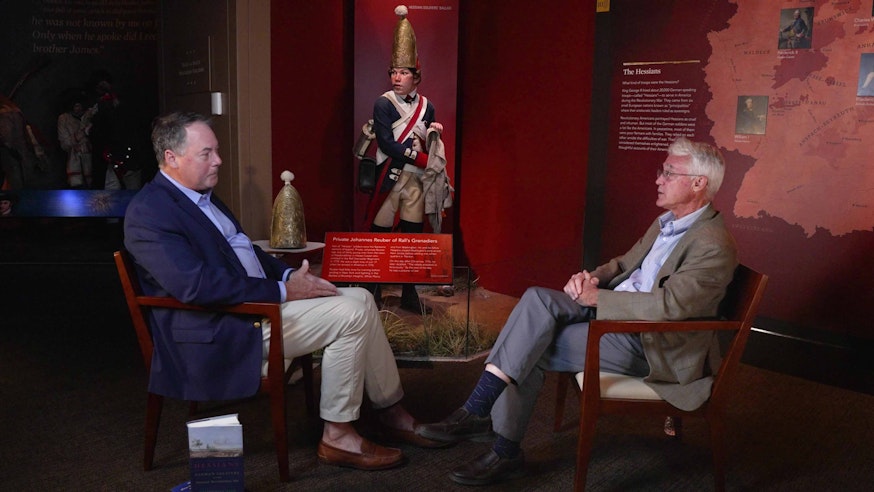 Dr. R. Scott Stephenson sits on the left facing archaeologist Wade Catts in the Museum galleries.
