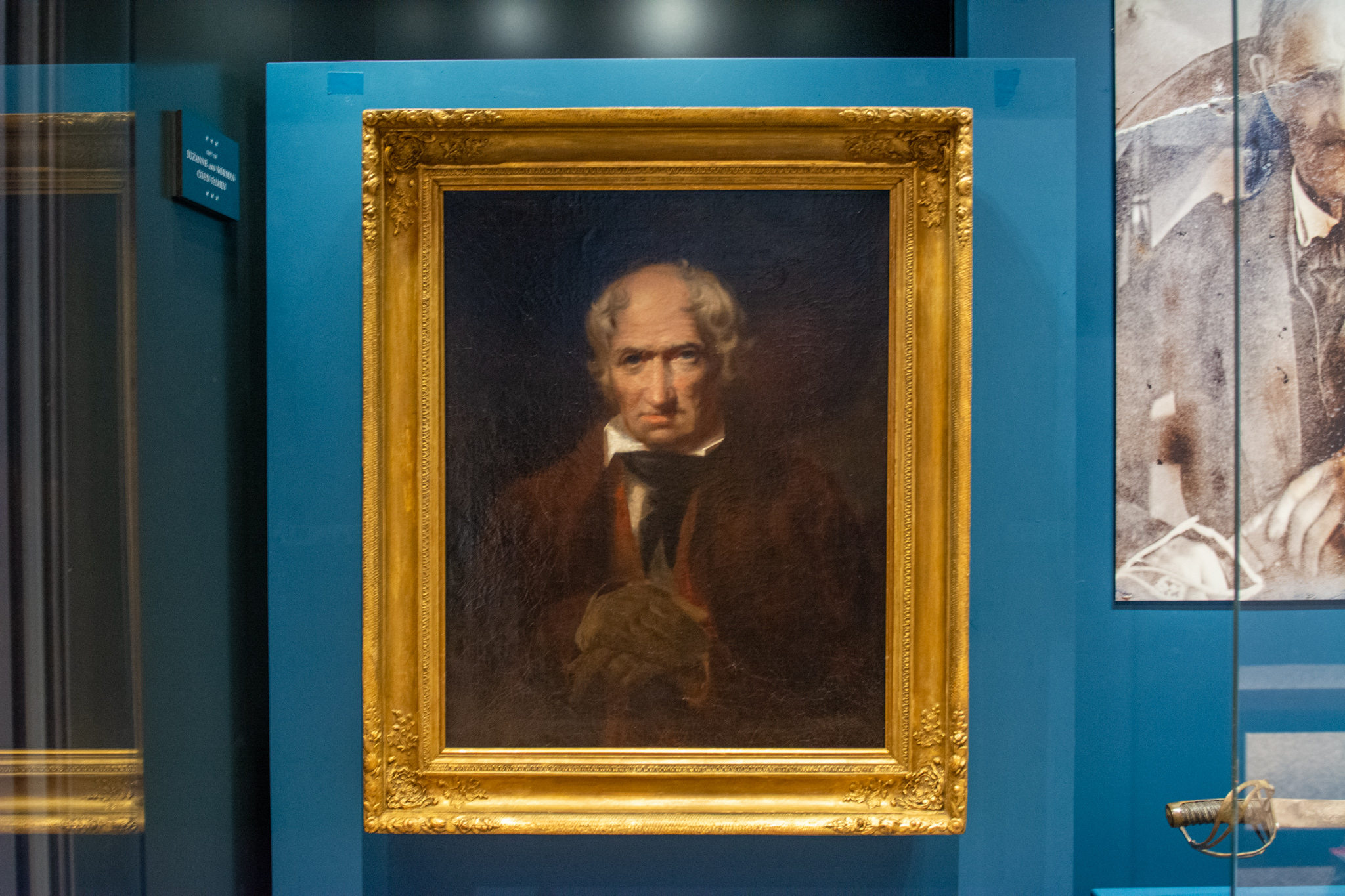 A portrait of a white man in 18th century clothing in a gold frame