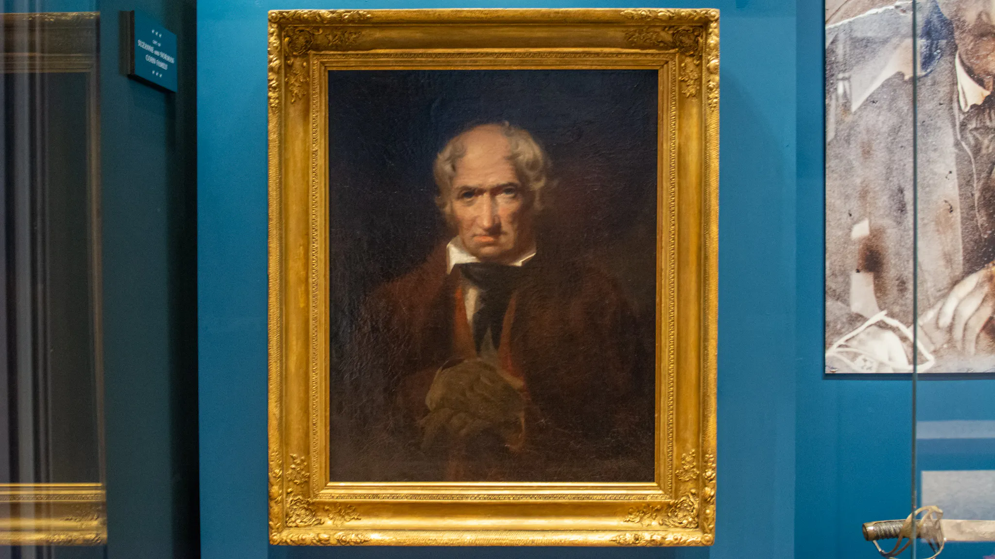 A portrait of a white man in 18th century clothing in a gold frame