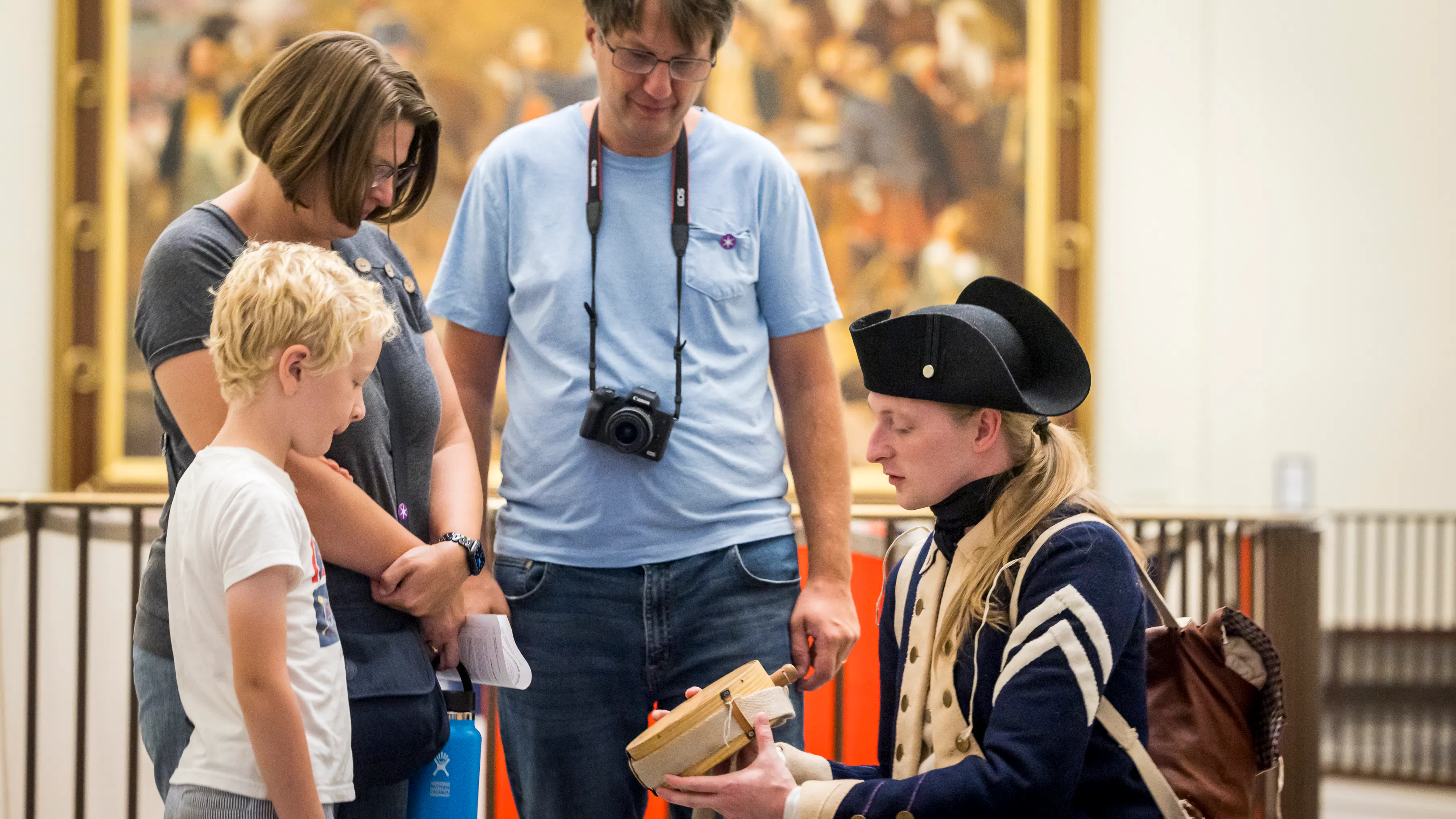A Costumed Living History Interpreter showing a young child a canteen over Labor Day Weekend