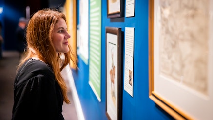 A guest views a painting in the Liberty Exhibit.