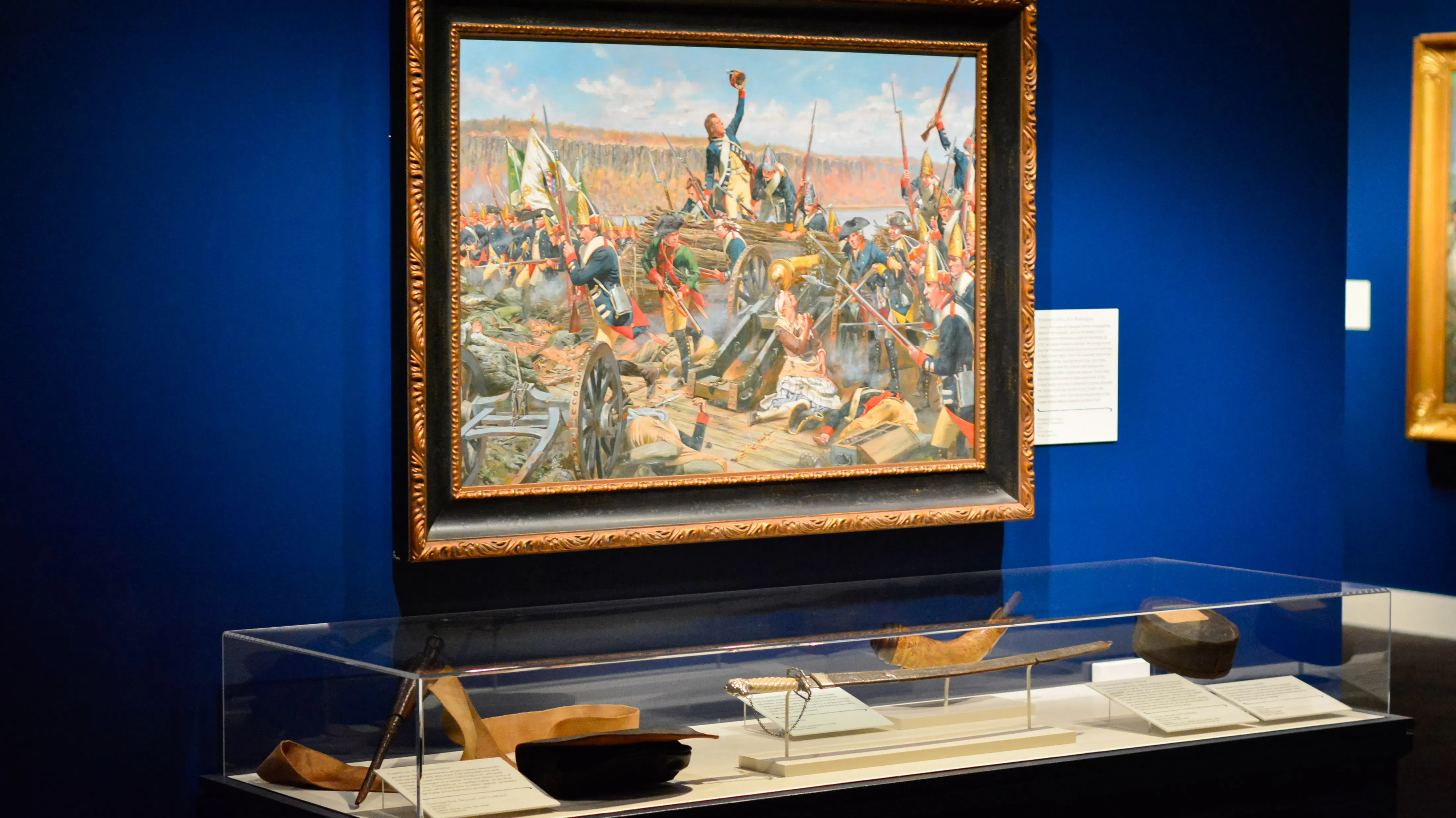 A painting by Don Troiani on view alongside objects depicted in the painting in the Museum's Liberty Exhibit
