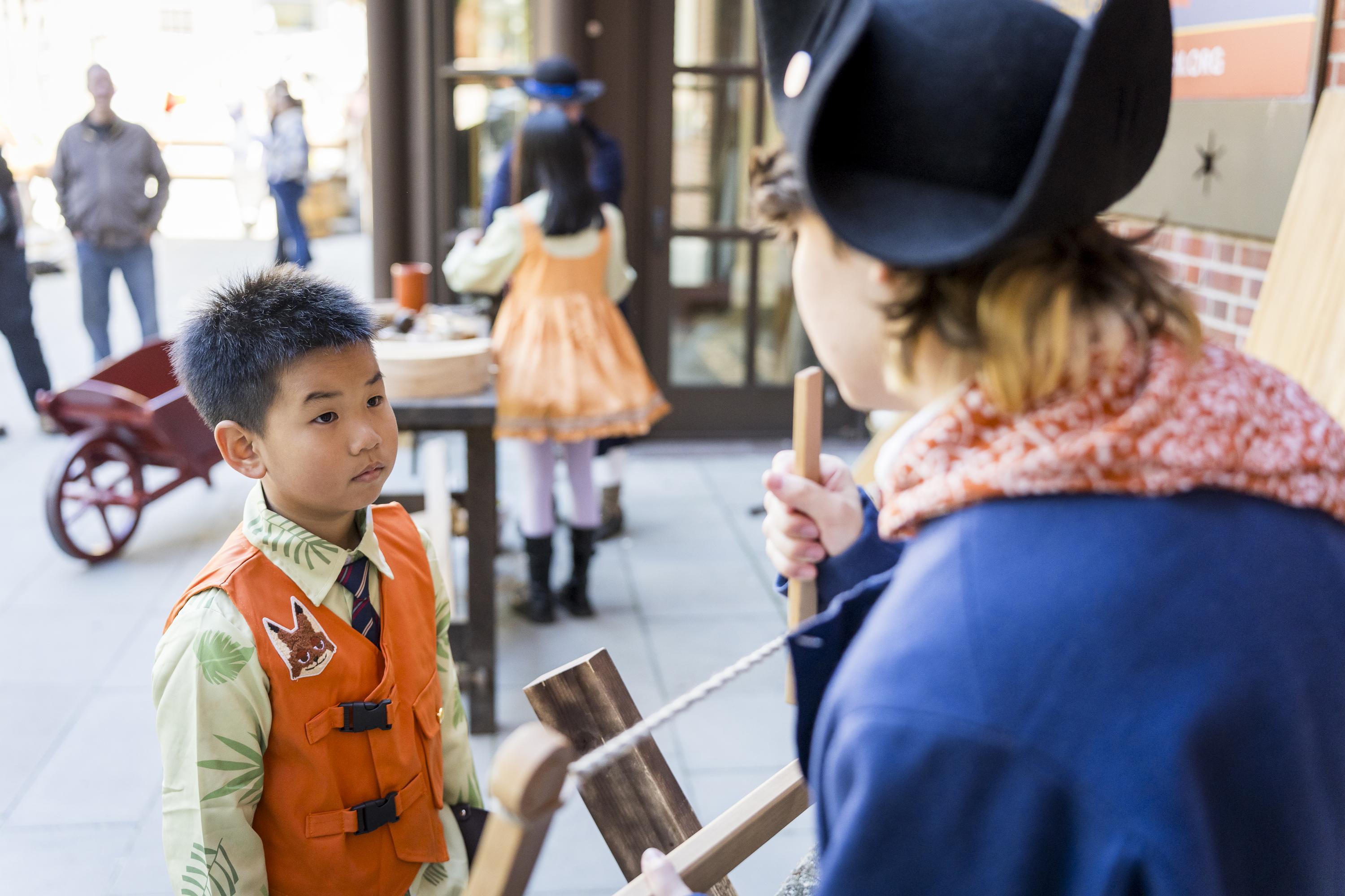 A child interacts with a costumed interpreter