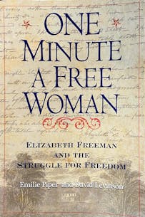 This image shows the book cover for One Minute A Free Woman with the title in large navy blue serif font over script writing on beige paper.