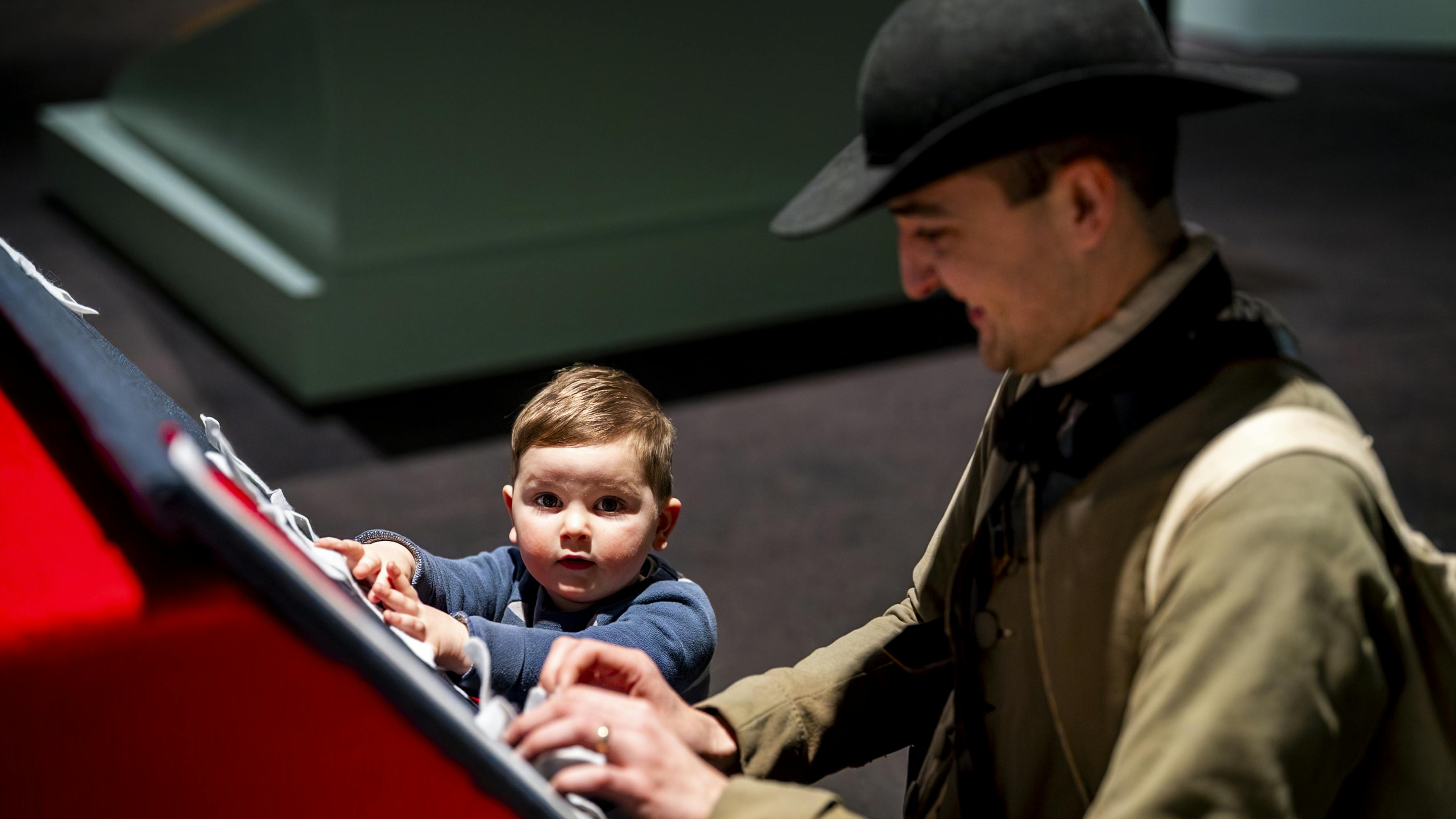 This photo shows a man in 18th-century clothing and a small child designing a flag at a felt crafting station.