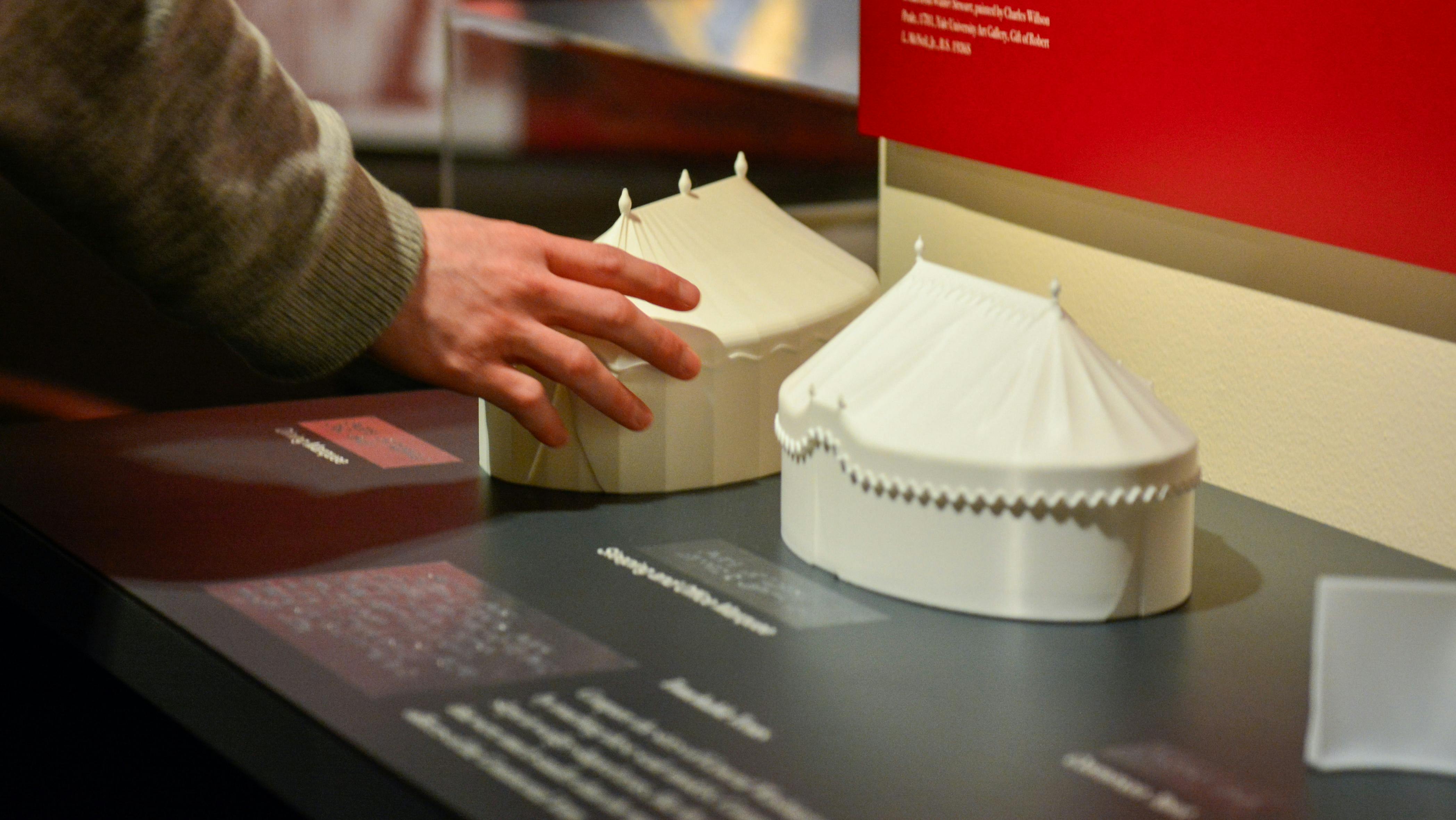 A guest touches one of the 3D-printed tactile versions of George Washington's tents in Witness to Revolution.