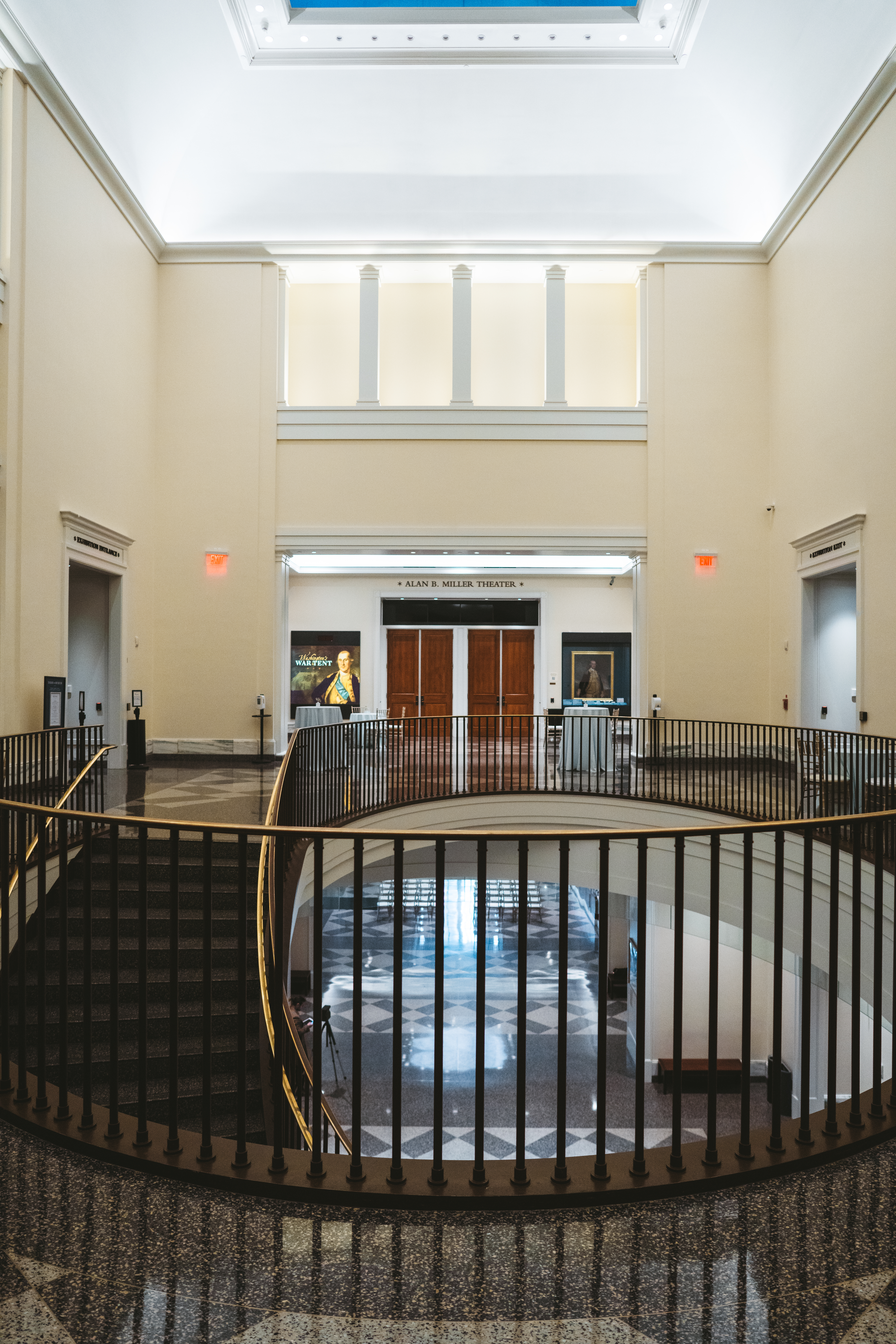 A railing in front of a door at the right and left and a door in the background