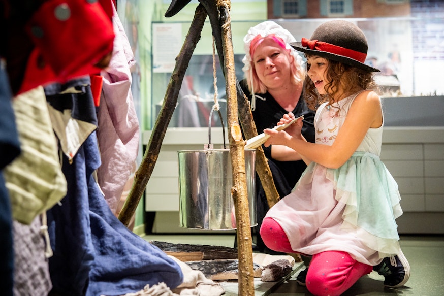 A mother and daughter interact at a replica encampment in the Museum's Revolution Place family discovery center.