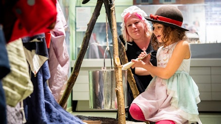 A mother and daughter interact at a replica encampment in the Museum's Revolution Place family discovery center.