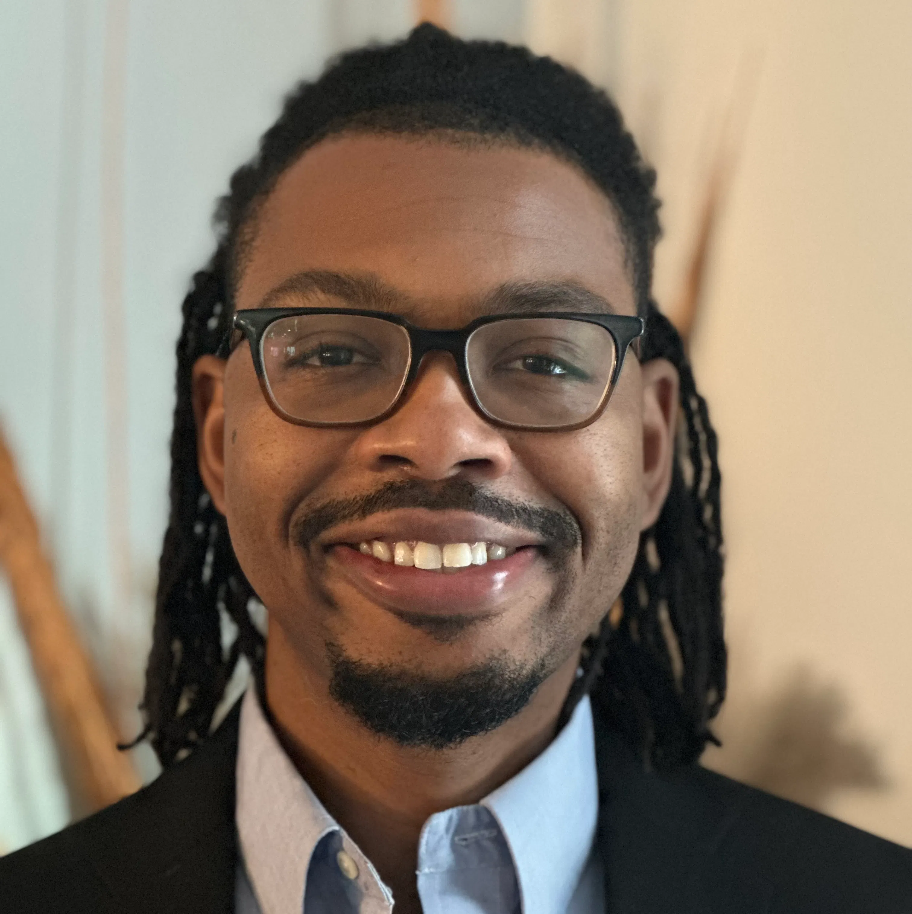 Portrait of Jason M Coles with glasses, a goatee, and shoulder length hair