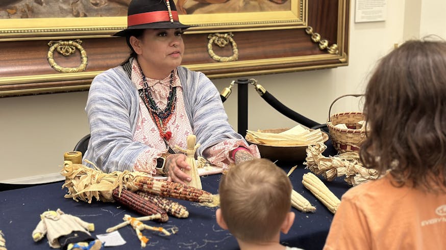Kehala Smith of the Tuscarora Nation shows young guests traditional cornhusk dolls.