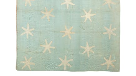 Revolutionary War flag with thirteen white six-pointed stars and a field of faded light blue