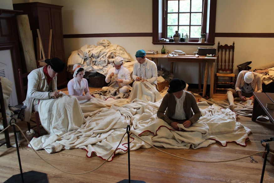 Staff members from the Museum of the American Revolution and Colonial Williamsburg work on sewing the Museum's replica of George Washington's headquarters tent
