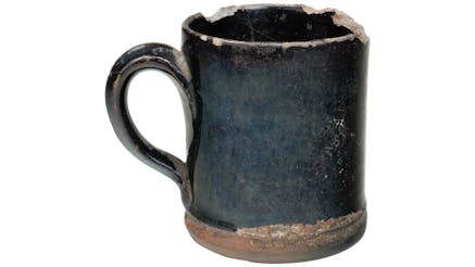 A bluish-black mug with chipped edges