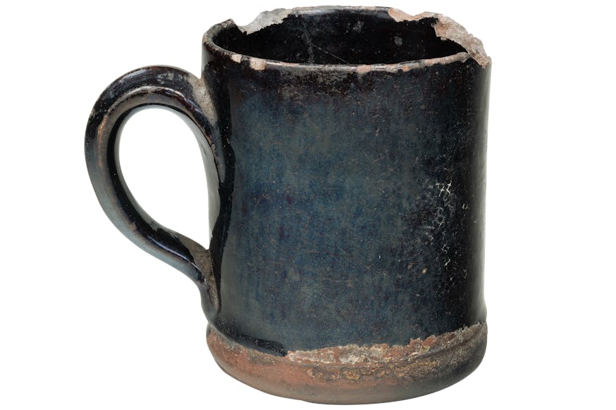 A bluish-black mug with chipped edges