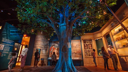 Visitors of the Museum of the American Revolution in the Liberty Tree gallery which features a Liberty Tree