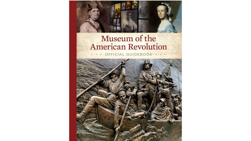 This image depicts the book cover for the Museum of American Revolution Official Guidebook. The bottom of the cover depicts a relief sculpture found on the building of the Museum of Washington crossing the Delaware River. The top of the book is written in red. And the top of the cover shows some of the galleries inside of the Museum.