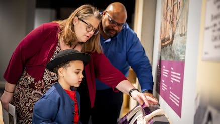 A family compares textures of pieces of sail cloth in the Museum's Black Founders exhibit.