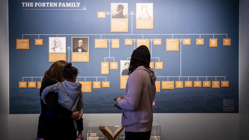 A family views the Forten family tree and family bible in the Museum's Black Founders exhibit.